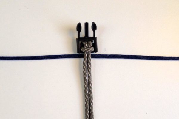 Lay your paracord so the center of the blue piece is behind the grey piece.