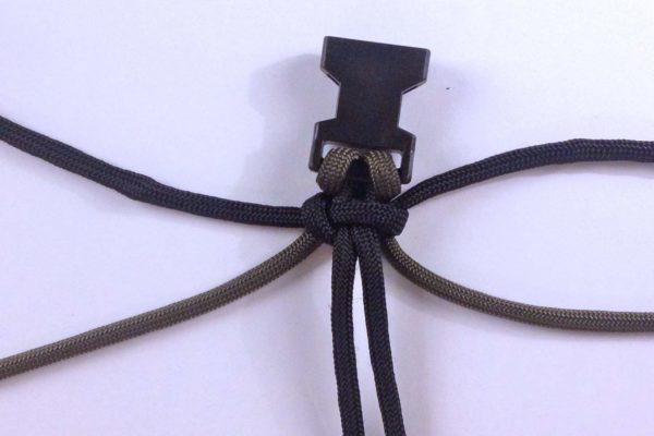 Tighten the black knot around the green paracord.