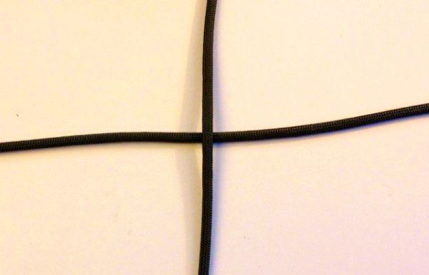 The first two strands of paracord and intersect them at the centers to form a cross | How To Make A Paracord Keychain 