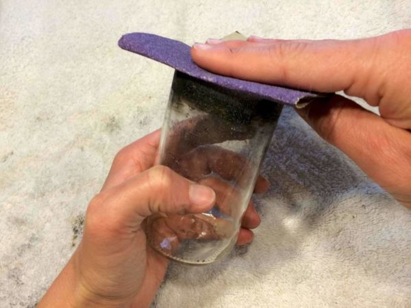 sanding edges of glass to finish the project: Read how to make glass cups out of glass bottles on DIY Projects.com