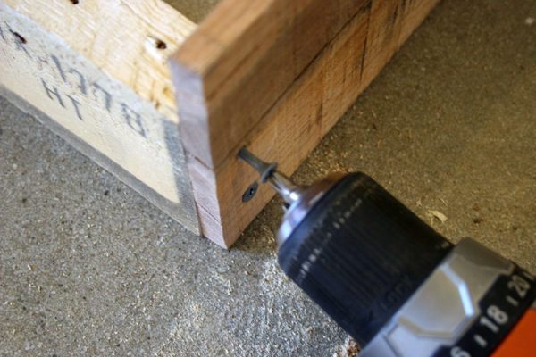 A screw going into some reclaimed wood.