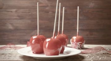 Plate with delicious candy apples on wooden table | Yummy Treats Made From Leftover Halloween Candy | Leftover Halloween Candy | leftover halloween candy recipes | Featured