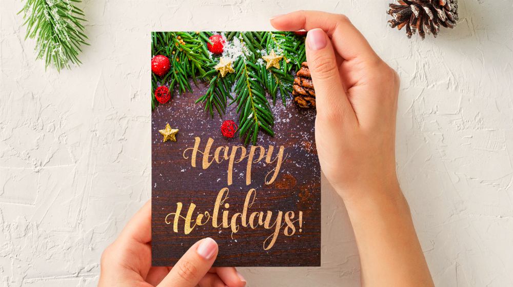 person holding holiday card | How To Make DIY Gift Tags From Upcycled Holiday Cards | DIY Gift Tags | handmade gift tag ideas