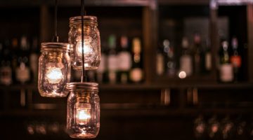 DIY light bulb cover, hanging lamps made from glass jars with wine shelf bar blurry background | How To Make A DIY Mason Jar Chandelier | Featured