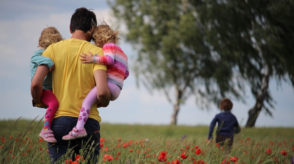 Man carrying to girls on field of red petaled flower | DIY Father's Day Gift Ideas To Make Your Dad Feel Loved | Featured