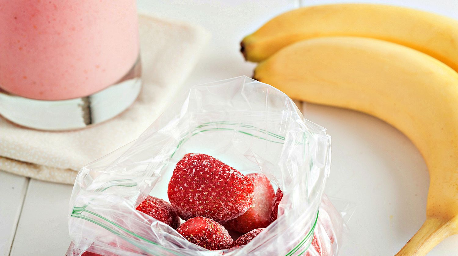 Feature | A smoothie ingredient frozen strawberries in clear plastic bag | DIY Smoothie Freezer Kits | Make Ahead Smoothie Recipes