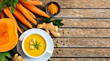 Seasonal spicy fall vegetables creamy pumpkin and carrot soup with ingredients on a rustic wooden table | Recipes For Early Fall | Tasty Dishes To Try This Season | Featured