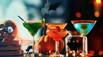 Close up view of colorful cocktails and decor for Halloween party, on blurred background | Ghoulishly Good Halloween Cocktails | Featured