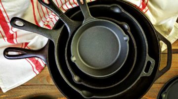 Feature | Cast iron skillet on rustic wood table | How To Season & Restore A Cast Iron Skillet | Kitchen DIY