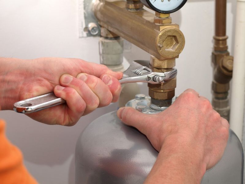 men-hands-screwing-valve-spanner | furnace maintenance