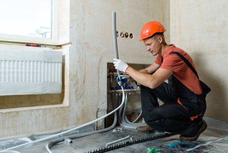 worker-installing-pipe-warm-floor-apartment | furnace tune-up checklist