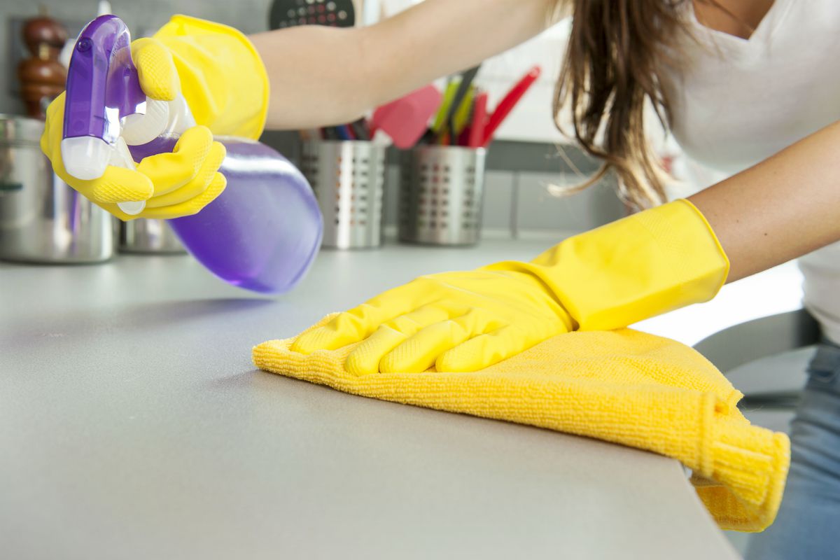 woman wearing gloves and cleaning the table | Day House Spring Cleaning Challenge
