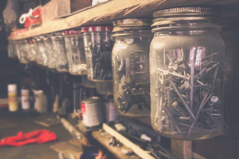 Mason jars filled with various nails | Hang Mason Jars Under Shelves