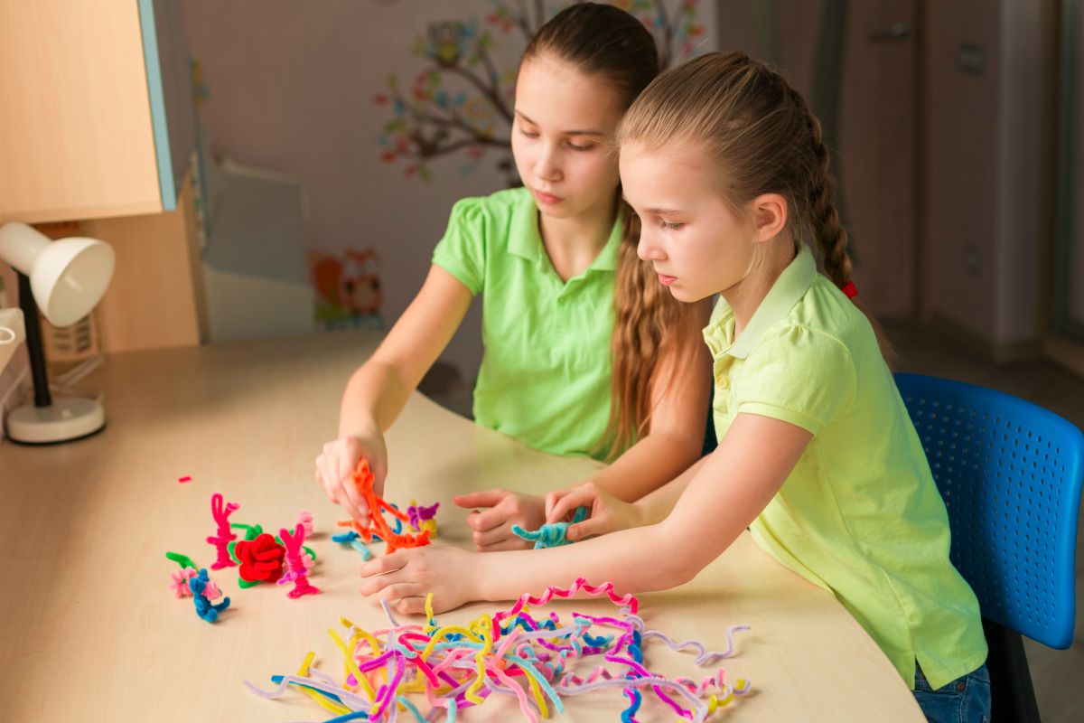 دختر بچه های بامزه با چوب شنل روی میز اسباب بازی درست می کنند |  پروژه های کاردستی بهاری که باید در این فصل امتحان کنید |  پروژه های DIY