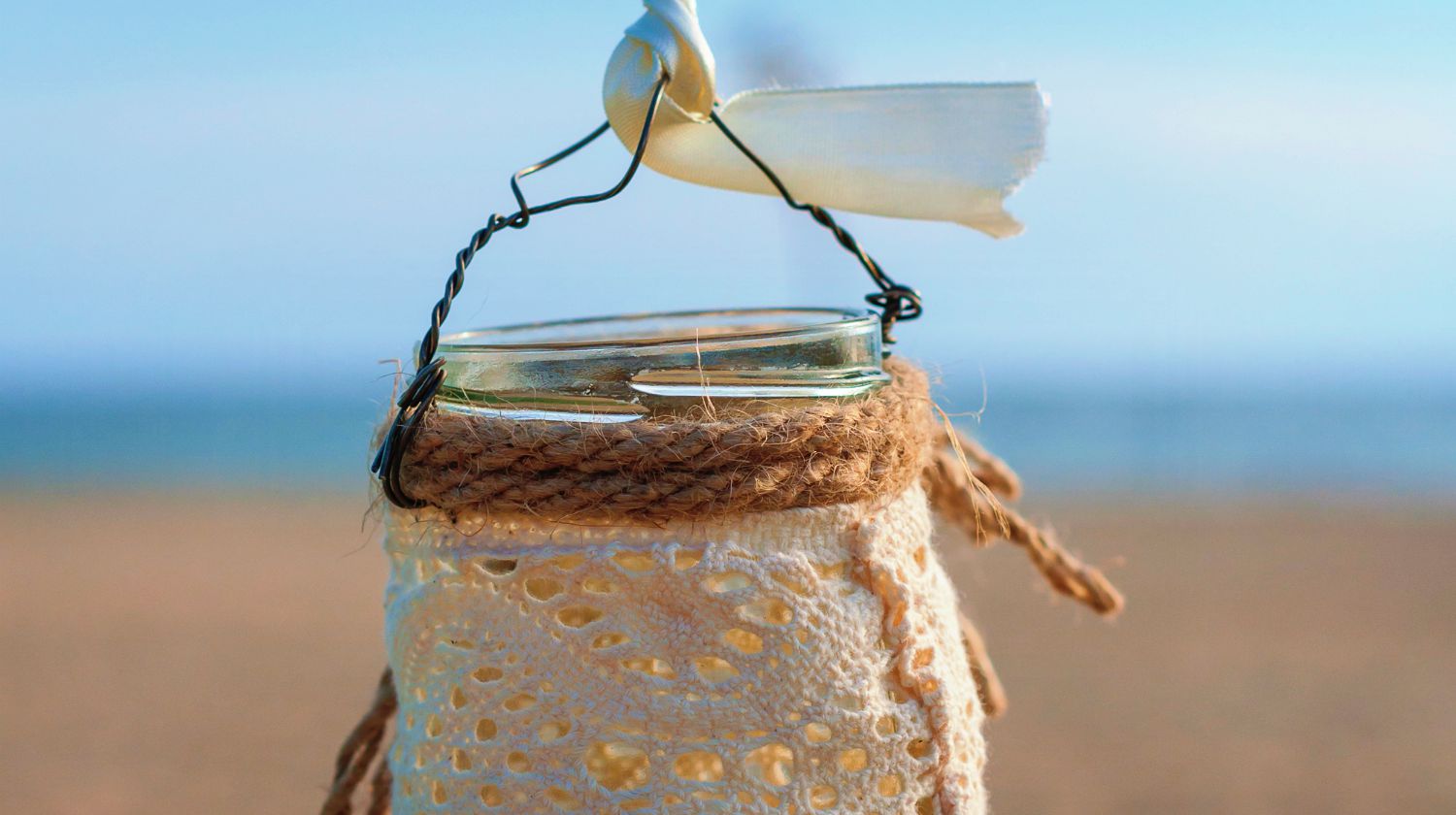 Jar with lace for candle on the beach and sea background | Fun Fall DIY! Make Your Own Rustic Candle Sconces | Featured