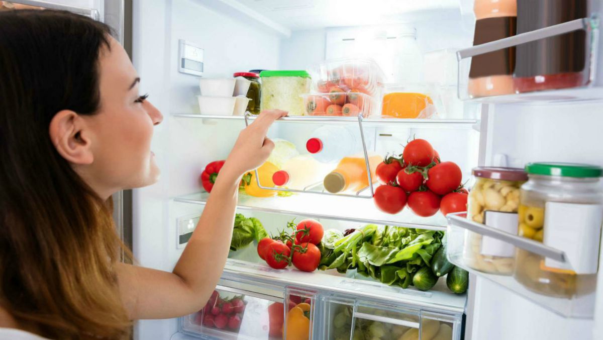 Woman looking in the fridge | 10-Minute Cleaning Hacks To Keep Your Home Sparkling