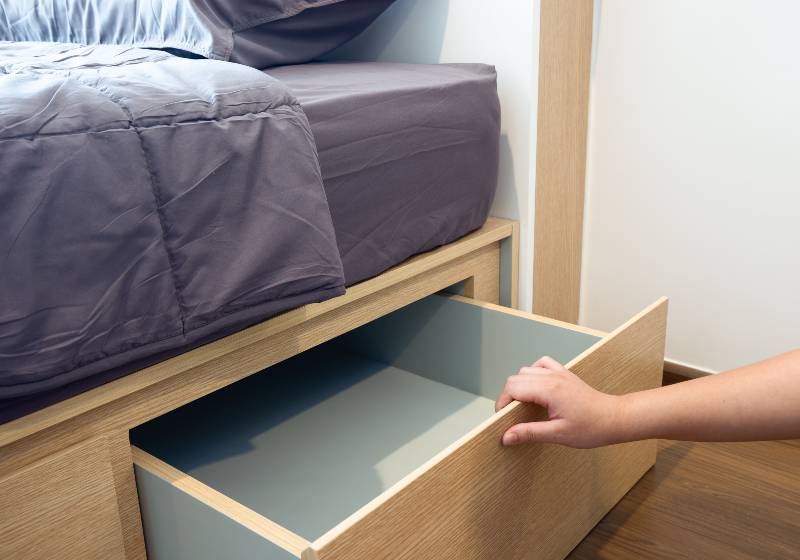 A human hand open the designed wooden drawer under the bed | Platform Bed With Storage