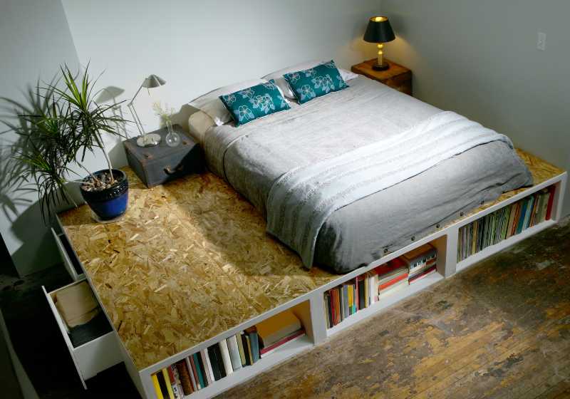 Modern trendy bedroom with bed on a platform forming a bookcase | DIY Cubby Queen Platform Bed (Thanks, Ikea!)