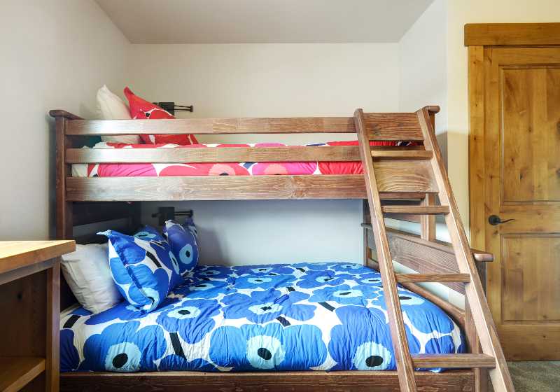 Room with two bunk beds and blue and red bedding with large flowers, grey carpet | Bunk Bed Platform | DIY Platform Beds