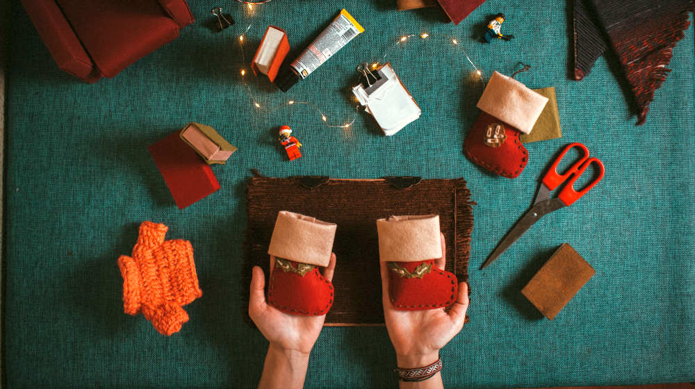 Person holding two red ornaments | DIY Christmas Stockings | Homemade Christmas Project | handmade christmas stockings | Featured