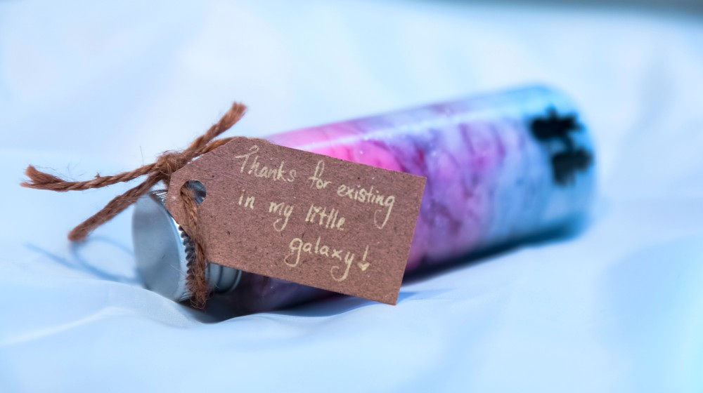 Thank you for existing in my little galaxy tag in a vial with colorful content in white background | Our DIY Christmas Ideas Roundup
