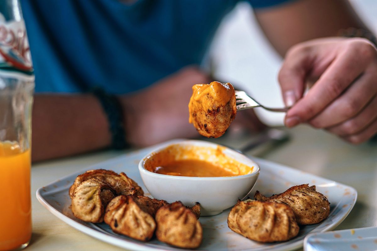 Man eating dumpling with sauce | Top (Delicious) Hot Sauce Recipes You Can Make