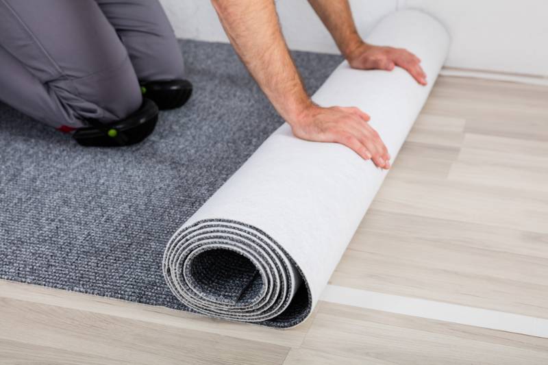 close-workers-hands-unrolling-carpet-on | diy soundproofing panels