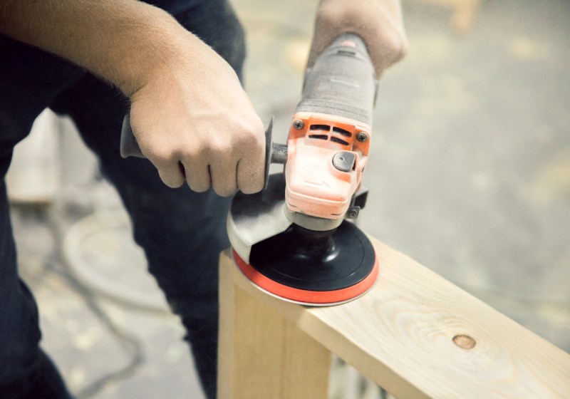 man holds grinds piece wood grinder | folding workbench plan