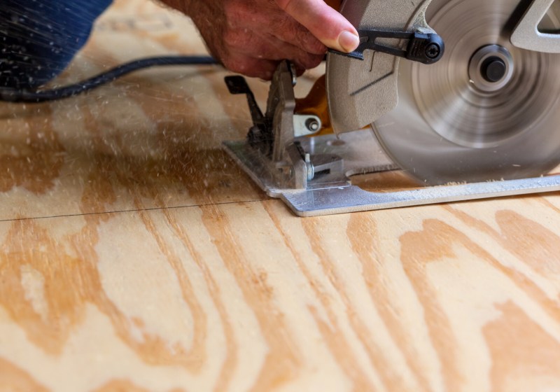 man using circular saw cut plywood | dewalt folding workbench