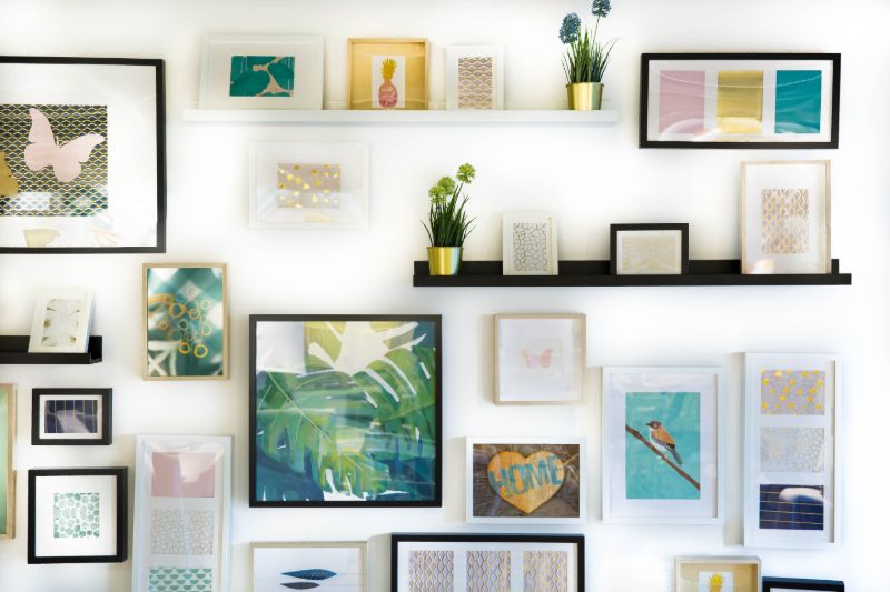 assorted color framed paintings on the wall | wood working