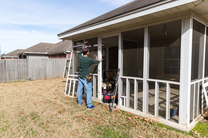 homeowner-works-on-repairing-door-screened | diy backyard ideas