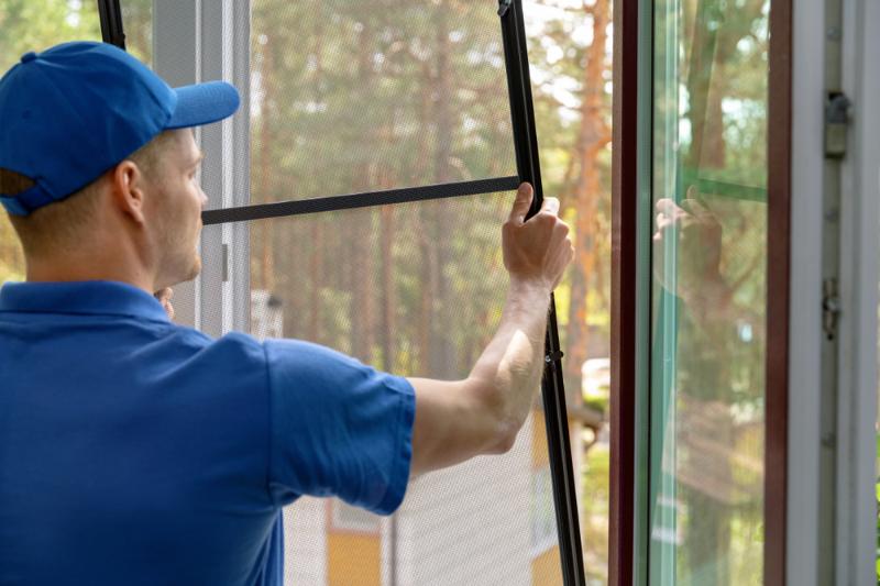 worker-installing-mosquito-net-wire-mesh | window screen repair tape