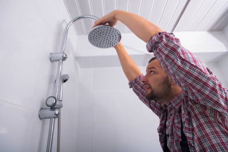 workman repairing shower head bathroom | diy home decor