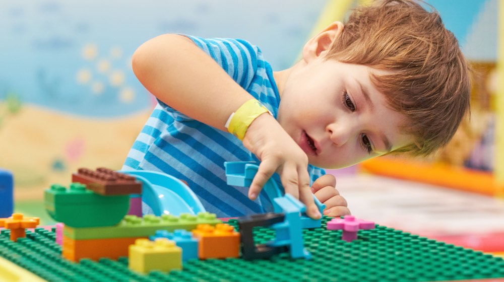 boy playing lego | DIY Lego Table Ideas For Countless Hours of Creative Fun | featured