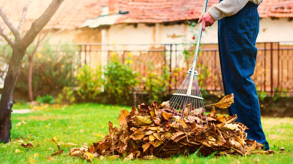 man raking leaves | Fall Home Maintenance Checklist: How To Prepare Your Home For Fall | fall maintenance checklist |