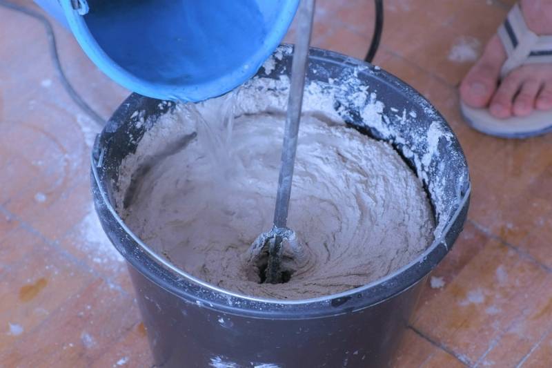 builder mixing cement plaster bucket using | cheap squat rack