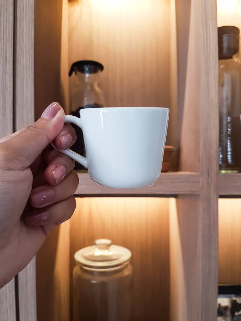 hand-holding-white-coffee-cup-by | 11 DIY Coffee Bar Ideas For Your Home