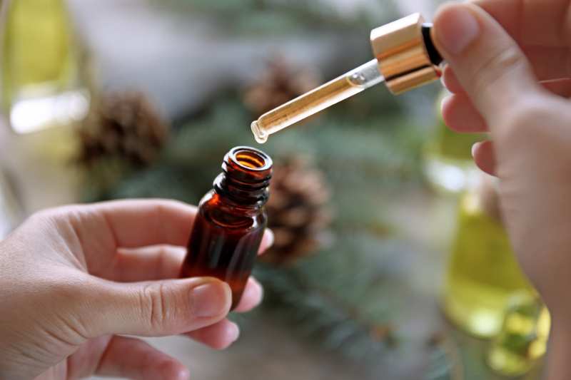 woman filling bottle pine essential oil | pine scent
