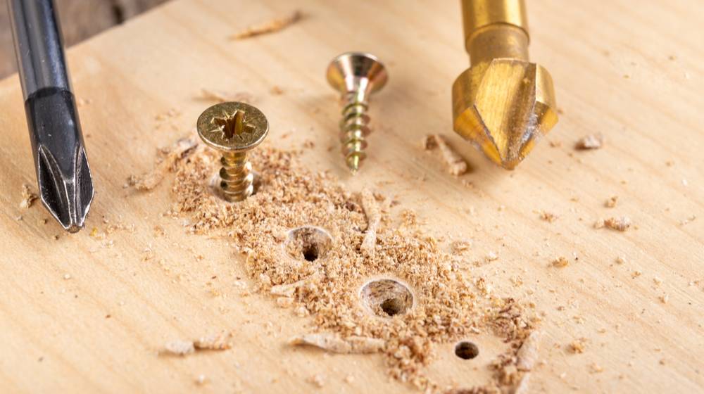 screwing-metal-screws-into-chipboard-furniture | How To Properly Fix A Stripped Screw Hole | Featured