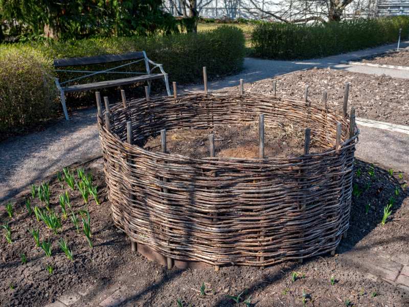 weaved-wooden-composter-wicker-basket-placed | dried leaves