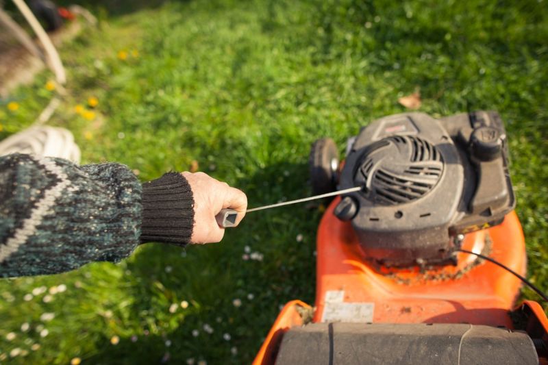 Senior-Mann-Hand-Start-Orange-Mäher |  Rasenmäher reparieren oder austauschen