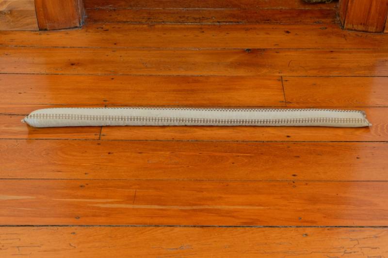 draught-sausage-on-wooden-floor | best door draft stopper