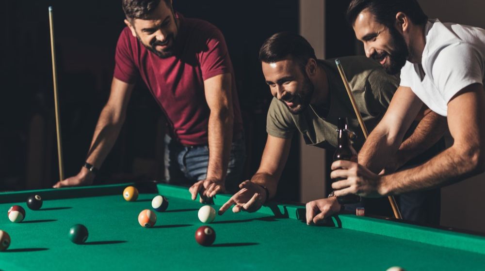 group-young-handsome-men-playing-pool | DIY Pool Table You Can Make For Your Man Cave | Featured