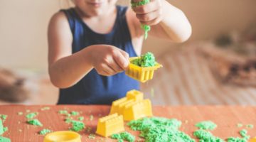 little-child-girl-playing-green-kinetic | How To Make The Perfect DIY Kinetic Sand For Your Kids | Featured