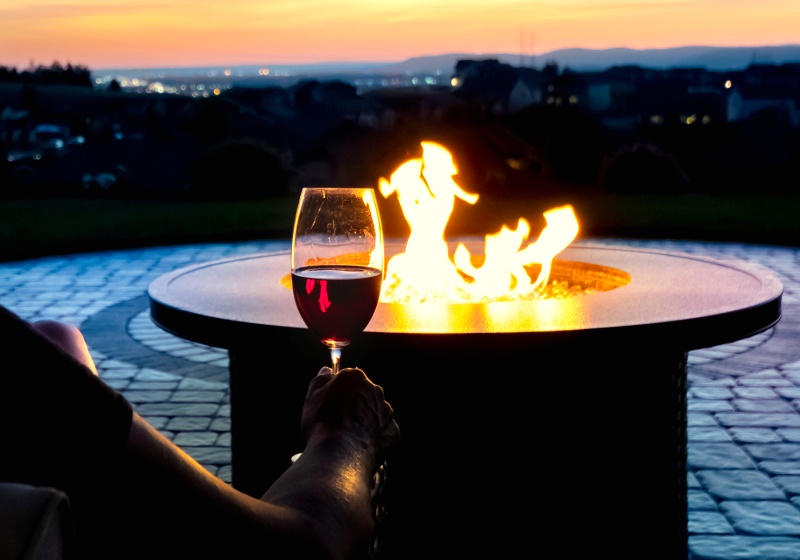 woman relaxes glass wine sunset by 1824929903 | DIY Propane Fire Pit For Chill Evenings