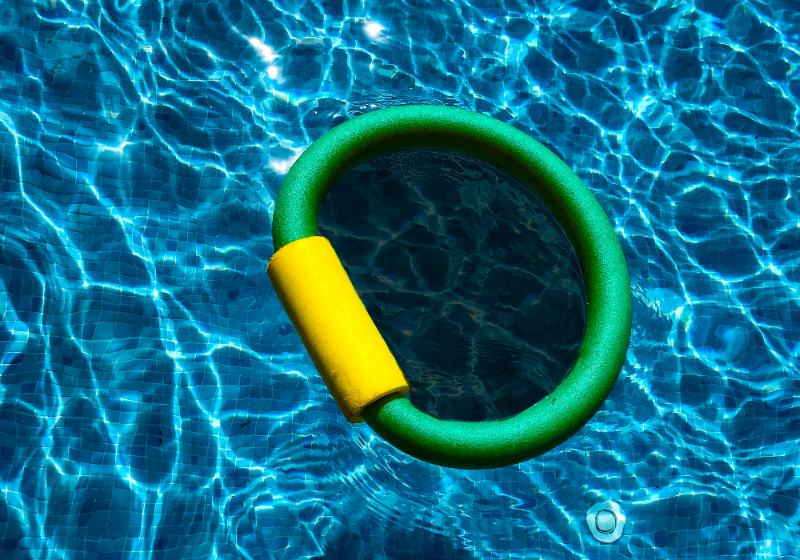 green and yellow rubber floater on blue water | how to heat a pool fast diy
