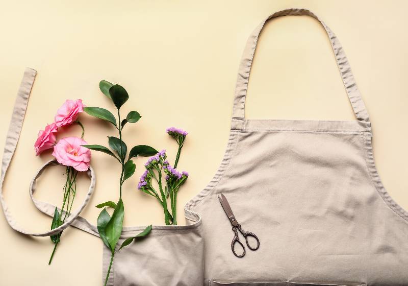 Apron, flowers and scissors on color background | Convertible Harvest Apron And Produce Bag