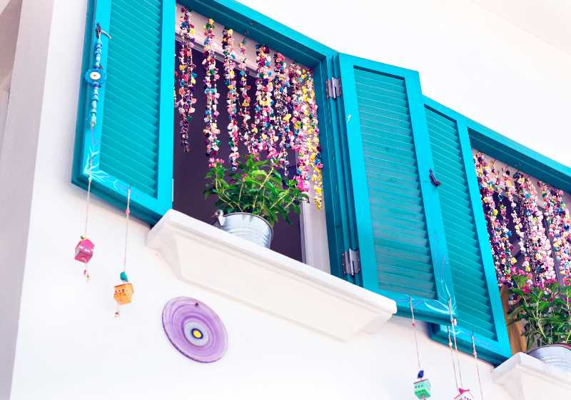 Blue window on white house wall with pot flowers and colorful hand made wind chimes | Balsa Wood Fall Wind Chimes | Easy Woodworking Projects For Kids