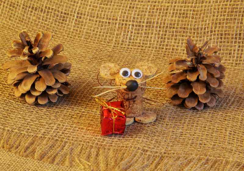 Charming homemade mouse made of natural wine cork with gift and large fir cones on jute coarse homespun cloth | DIY Wine Cork Charms