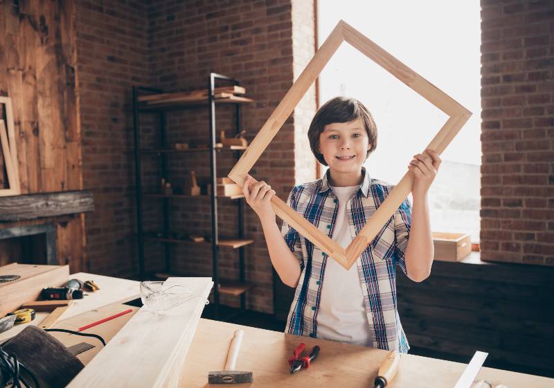 Portrait of nice cheerful cheery creative junior woodworker handyman creating frame | DIY Wood Frame | Easy Woodworking Projects For Kids